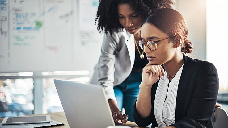 coworkers reviewing work on laptop
