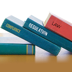 Spines of three books reading Compliance Regulation Law