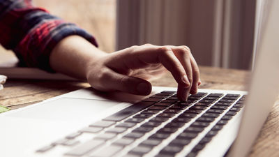 Close Up Of Hand Using Laptop Keyboard 