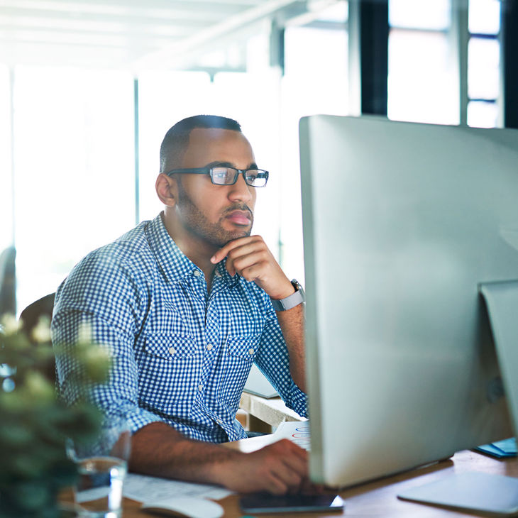 Person Concentrating On Desktop Computer Screen 