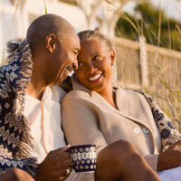 Happy Couple Sitting On Beach 