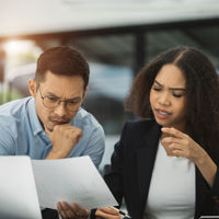 Two Colleagues Reviewing Documents And Laptop 