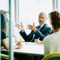Colleagues Discussing Work Around Conference Table 
