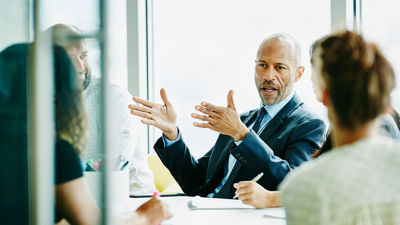 Colleagues Discussing Work Around Conference Table 