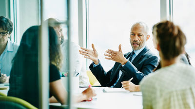 Colleagues Discussing Work Around Conference Table 