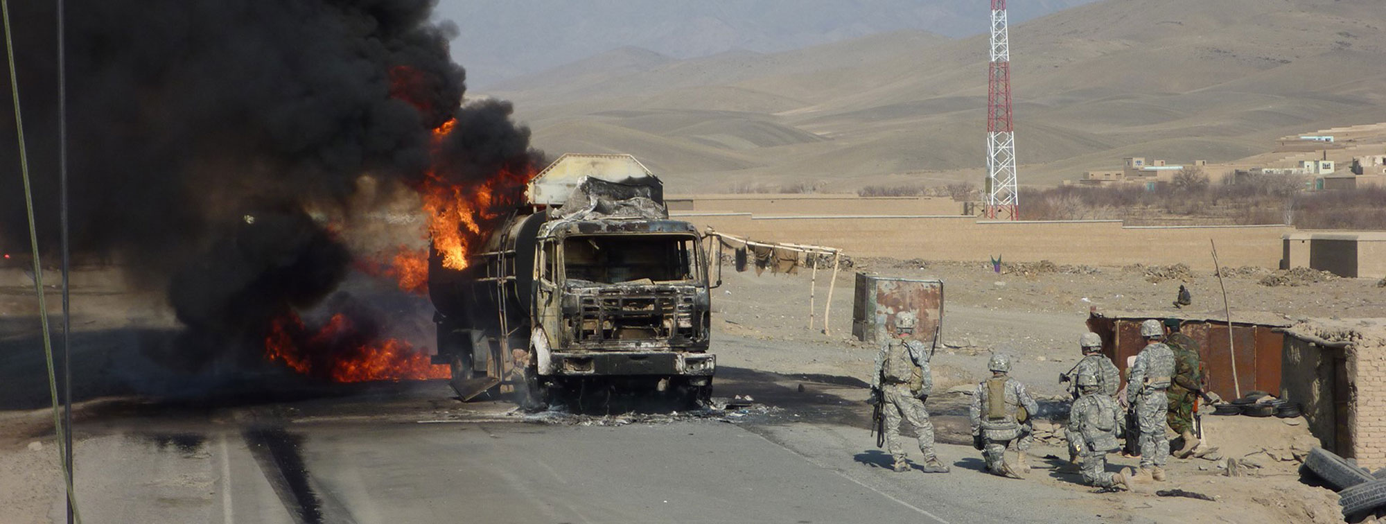 Truck On Fire With Troops Nearby 