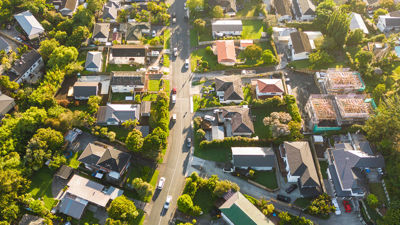 Aerial View Of Cars Driving Through Sunny Neighborhood 