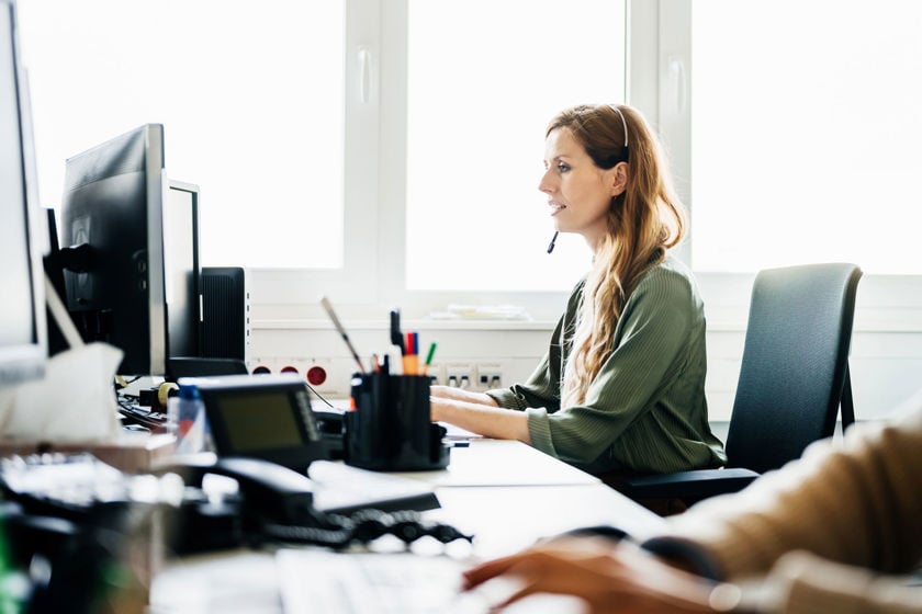 Office Worker At Computer Wearing Headset 