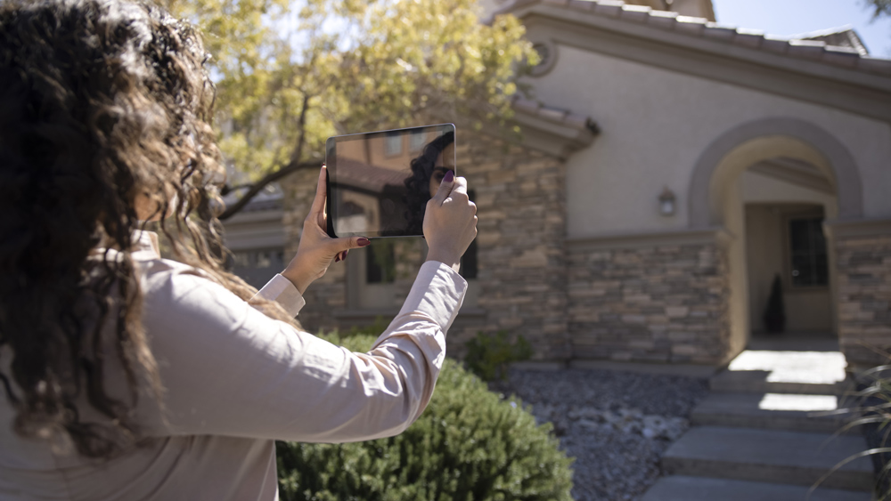 Woman taking photo of house