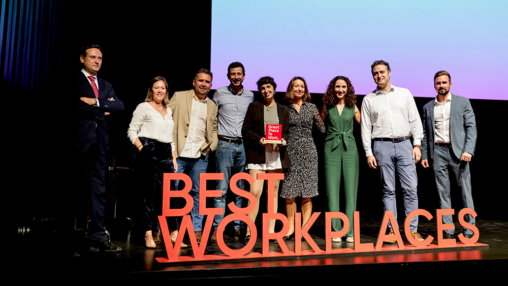 People on stage with Best Workplaces sign