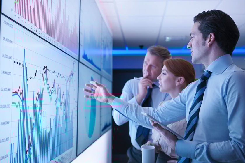 Group Of Colleagues Reviewing Data On Screens 