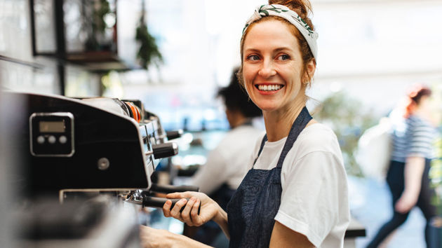 Smiling Barista Making Espresso In Coffee Shop 