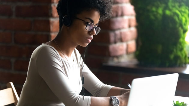 Woman Looking At Laptop With Headphones 