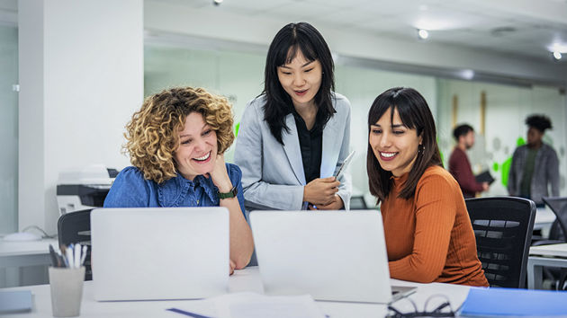 Coworkers Reviewing Data On Laptop Screens 