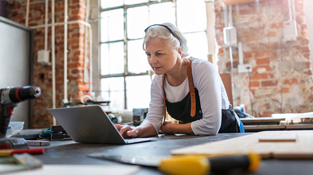 Woman In Workshop Looking At Computer 