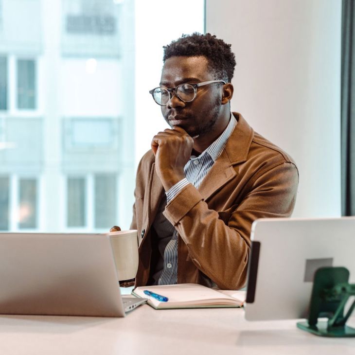 Man Reading Report On Laptop 