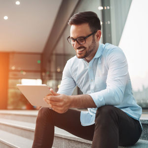 Smiling Individual Looking At Tablet 