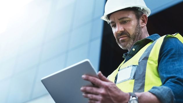 Man Looking At Tablet With Hardhat Vest Construction 