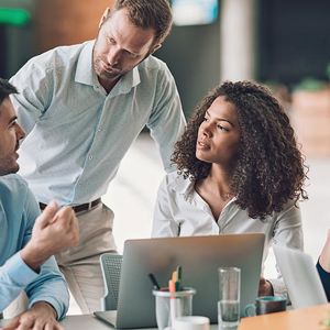 Coworkers Collaborating At Desk 