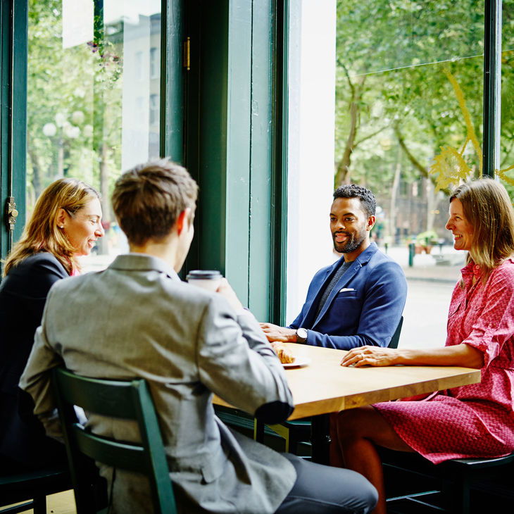 Colleagues Chatting In Coffee Shop 