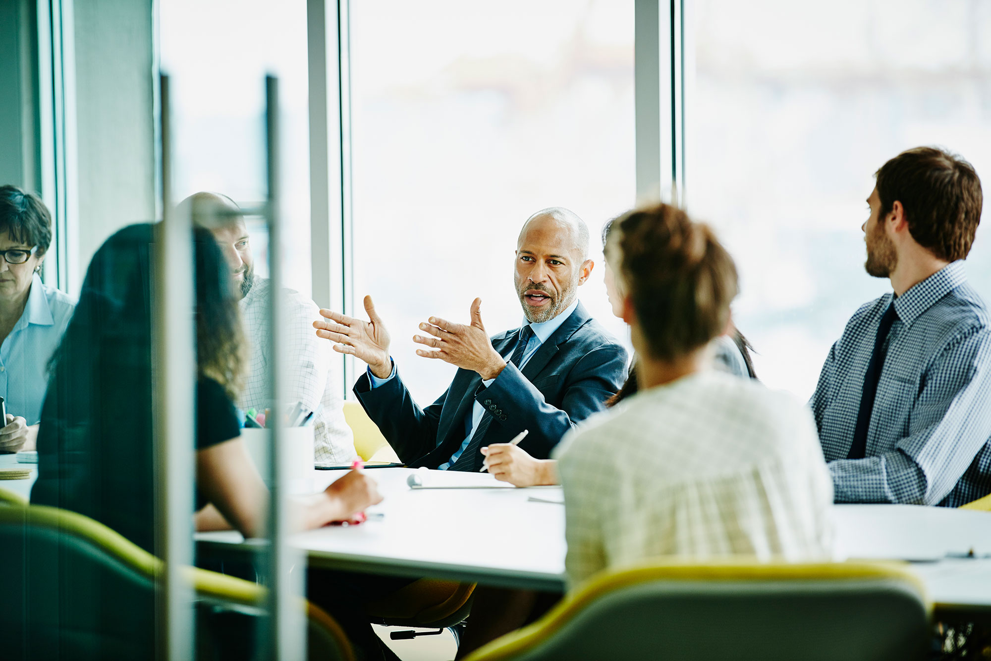 Colleagues Discussing Work Around Conference Table 