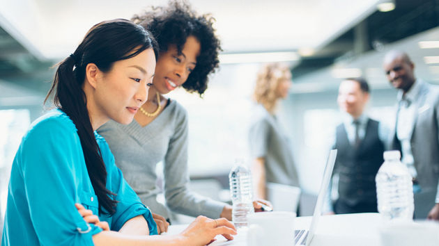 Colleagues Collaborating Over Laptop 