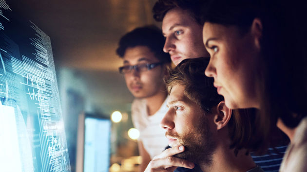 Individuals Reviewing Data On Screen 