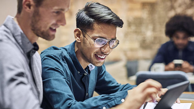 Coworkers Viewing Data On Laptop Screen 