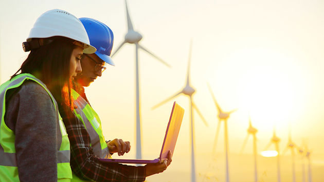 Workers Reviewing Data On Latptop In Windmill Farm3 