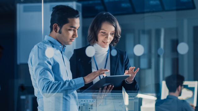 Man And Woman Reviewing Data On Tablet 