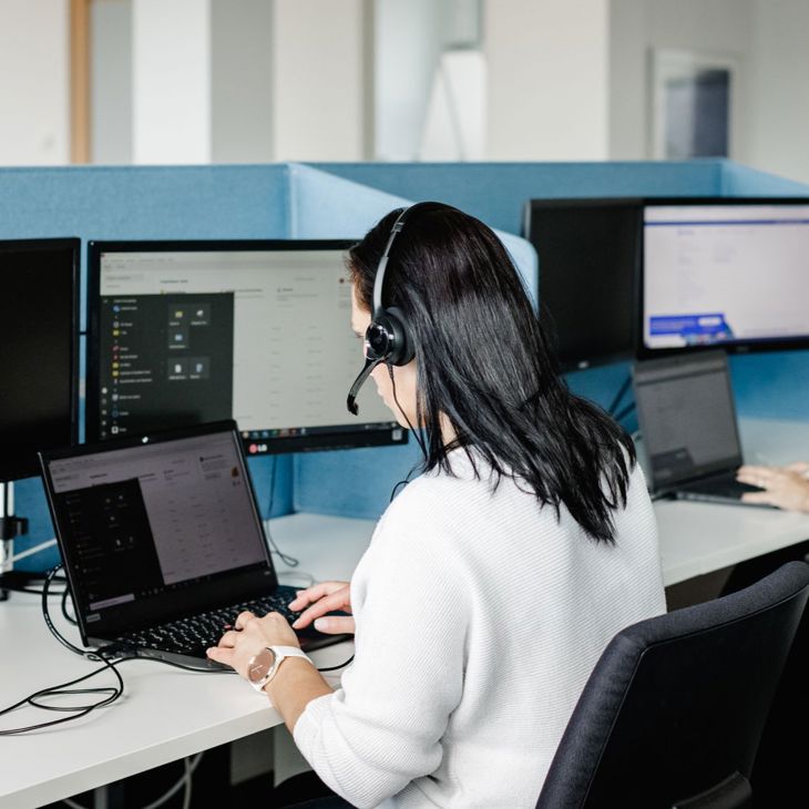 Woman With Headset Typing At Computer 