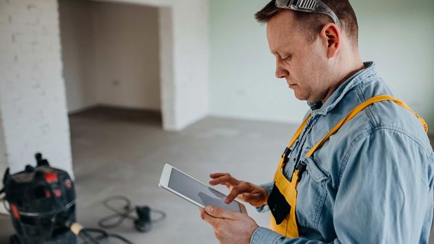 Contractor Using Tablet On Job Site 