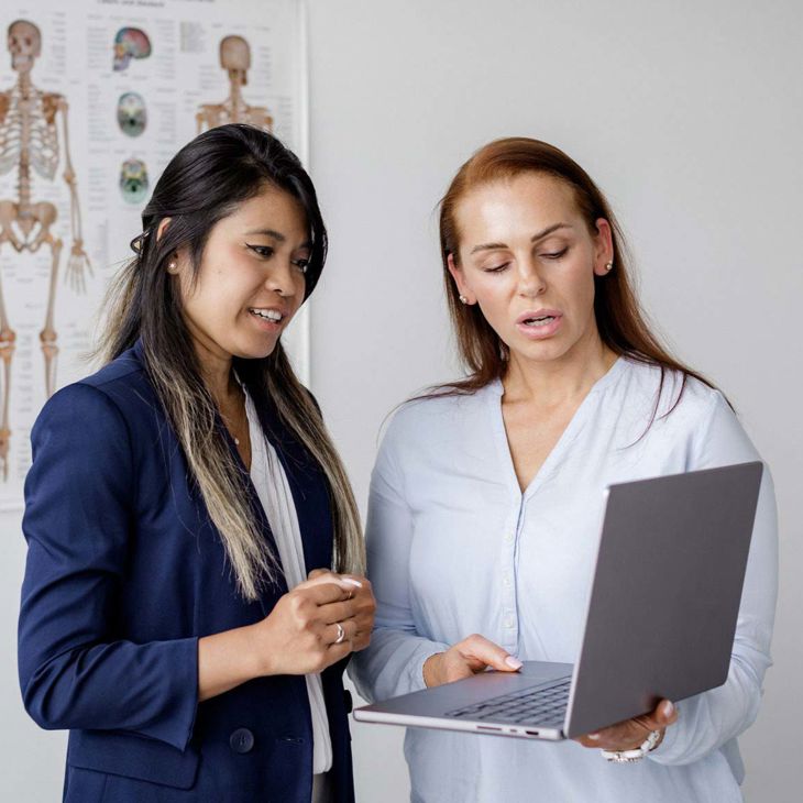 Two Women Reviewing Record On Laptop 