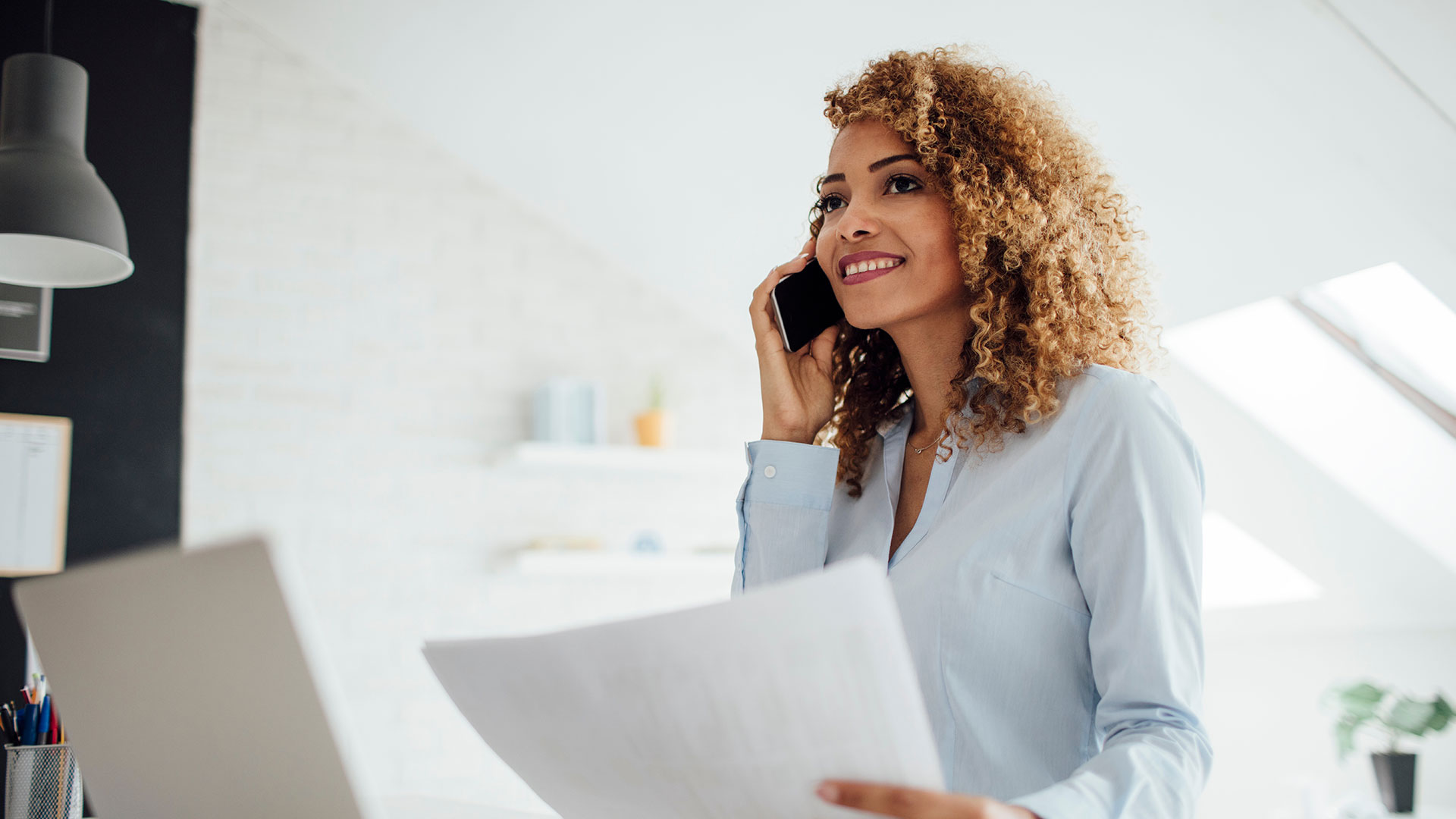 woman-talking-on-phone-holding-paper