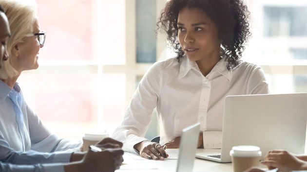 Colleagues Conversing Around Conference Table 