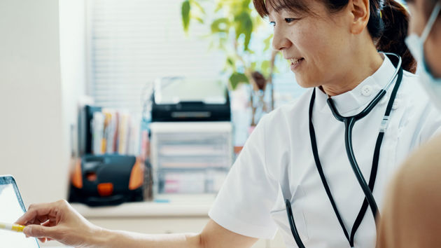 Doctor Consulting With Patient At Hospital 